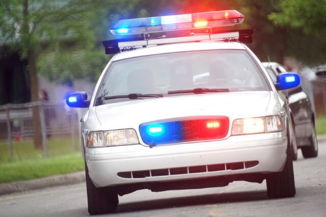 criminal-defense-legal-service a cop car driving down a street in indianapolis